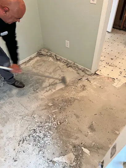 Wet floor tile being scraped off the slab during a Lake Elsinore water damage job