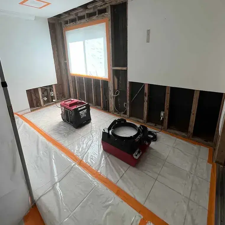 Dehumidifier and air mover drying a gutted room during water damage restoration in Lake Elsinore